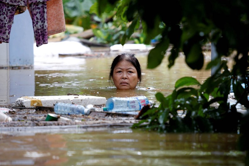 A woman wades through a submerged street at the UNESCO heritage ancient town of Hoi An after typhoon Damrey hits Vietnam